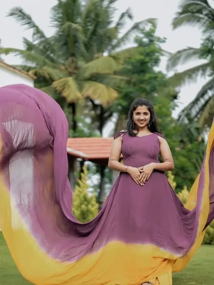 A front-facing view of the purple and yellow dual-tone flying gown, showcasing the full spread of the colorful tail.