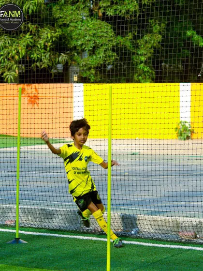 A young athlete weaves through agility poles, a drill designed to improve close control and the ability to change direction quickly.