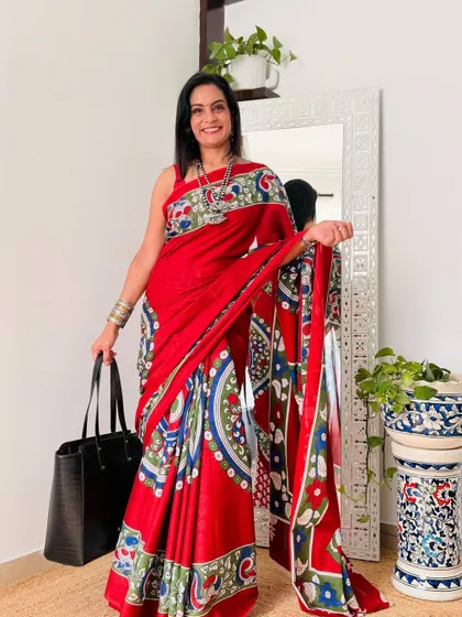 A vibrant red cotton mulmul saree with a multi-color print. This is a bold and beautiful piece that is sure to make a statement.