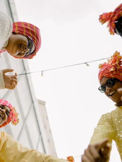 The groom's crew brings the energy! A fun, low-angle shot captures the groomsmen dancing and celebrating during the Haldi ceremony.
