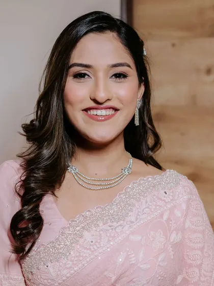 Her smile lights up the room. The makeup is fresh and luminous, perfect for celebrating her engagement.