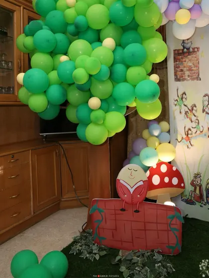A cozy corner of the ONEderland, featuring a Humpty Dumpty prop sitting on his wall, a giant mushroom, and a lush green balloon "tree" creating a magical, storybook feel.