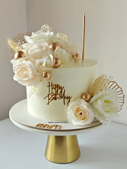 A timeless combination of white and gold. This minimalistic cake is adorned with soft white flowers and elegant golden touches for a beautiful birthday celebration.
