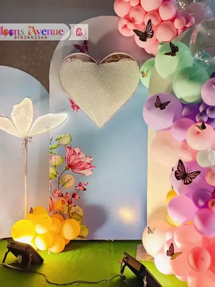 A close-up on the butterfly-themed backdrop, featuring a plush heart and floral details.