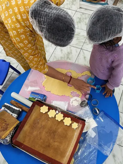 A close-up of a parent and child working together to make cookies. These shared experiences create lasting memories and strengthen our community bonds.