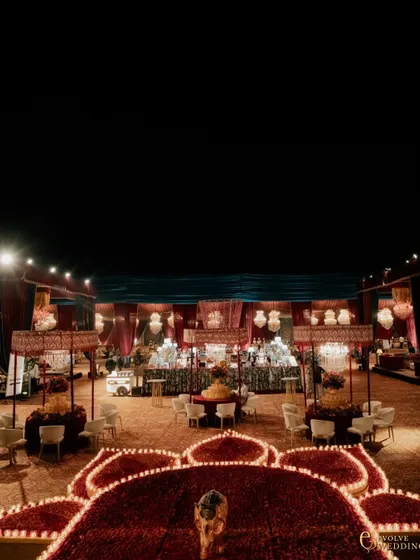 An overhead view of the dining area, where tables are crowned with patterned canopies and illuminated by candlelight. The design creates a warm, intimate atmosphere for thousands of guests against a backdrop of regal splendor.