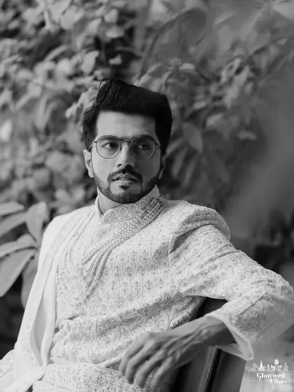 A handsome black and white portrait of the groom, Sanjay, looking away, creating a timeless and contemplative image.