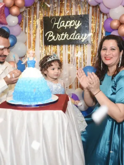 A candid shot of the family clapping and celebrating as confetti falls during the cake-cutting ceremony.