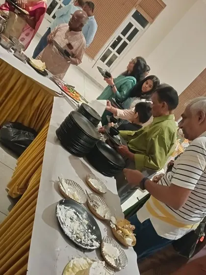 Guests lining up at the buffet during a housewarming and anniversary celebration. We ensure the food flow is smooth and organized, even at busy events.