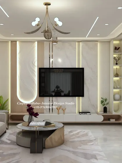 A luxurious living room TV unit featuring a combination of white marble, light wood, and vertical grooves. The built-in display niches are backlit to highlight decorative items.