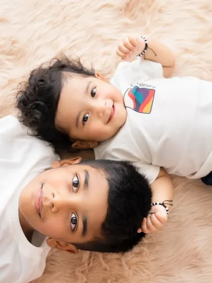 An overhead shot of two brothers lying on a soft rug. This perspective creates a lovely, intimate portrait.