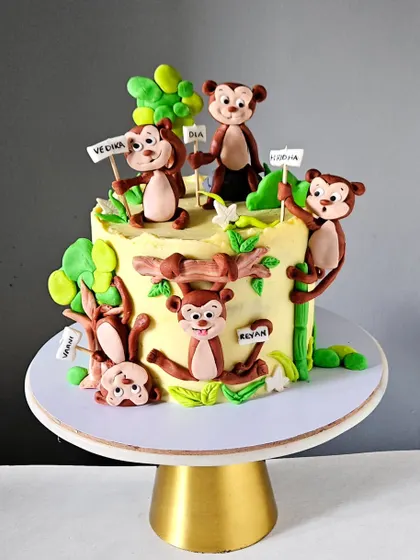 A playful "Five Little Monkeys" cake, where each monkey represents a child in the family. I gave each hand-sculpted monkey a unique, mischievous expression, and they are all playing in a colorful jungle scene.