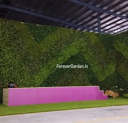 A wide shot of the event stage with the custom artificial green wall, demonstrating how we can create branded environments for corporate functions.