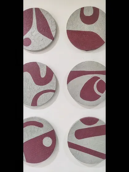 A direct, close-up view of six of the textured circular panels. You can see the raised texture of the base and the smooth, contrasting maroon shapes that form a continuous abstract design.