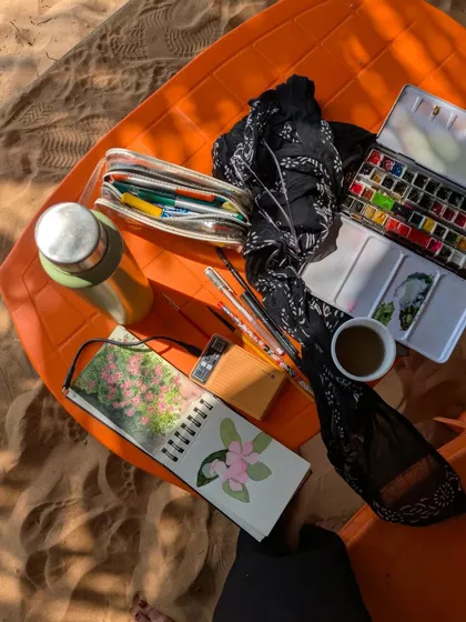 A glimpse of my painting setup during a trip to Gokarna. My sketchbook, watercolor palette, and a cup of tea are all I need to create on the go.