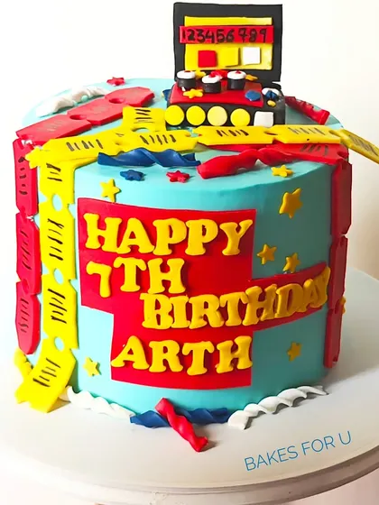 A bright and colorful Timezone arcade-themed cake for a 7th birthday. The design is packed with fun details like game tickets and an arcade machine topper, perfect for a little gamer.