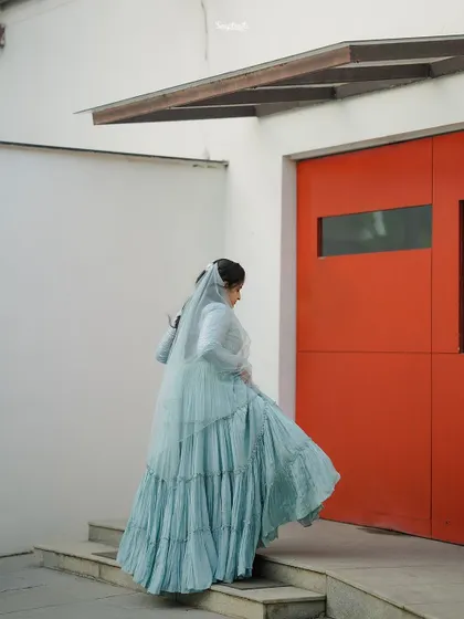 A candid shot of the bride walking up the stairs, the movement of her dress and the pop of the red door creating a dynamic and stylish image.