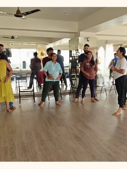 A group of expectant couples practices movement together, creating a supportive and energetic atmosphere. These shared moments build confidence and community among soon-to-be parents.