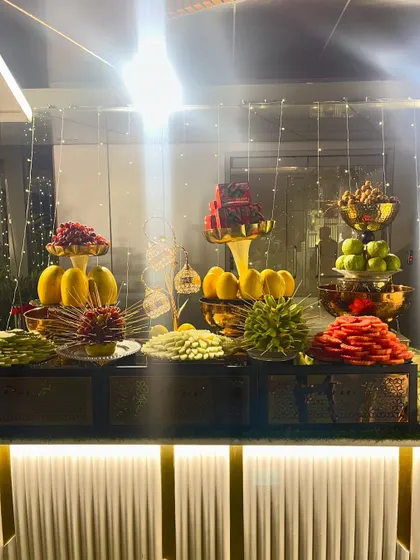 An artful arrangement of sliced fruits and berries under delicate string lights.