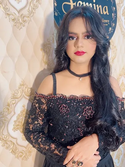 A portrait of the model in the black party dress, showing the full makeup and hair.