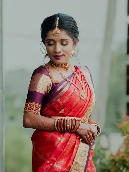 A candid moment captured, showing the graceful drape of the saree and the detailed embroidery on the blouse sleeves.