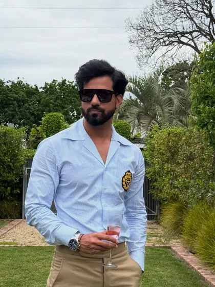 A closer look at the blue striped shirt, highlighting the crisp fabric and the elegant, embroidered crest that adds a touch of exclusivity.