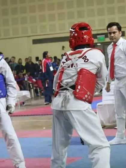 A student competes in a sparring match under the watchful eye of a referee. We prepare our fighters for the formal rules and pressures of tournament fighting.