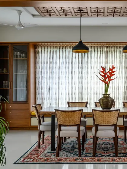 This dining room features a full-height, built-in crockery unit and a beautiful ceiling detail with Chettinad-style tiles.