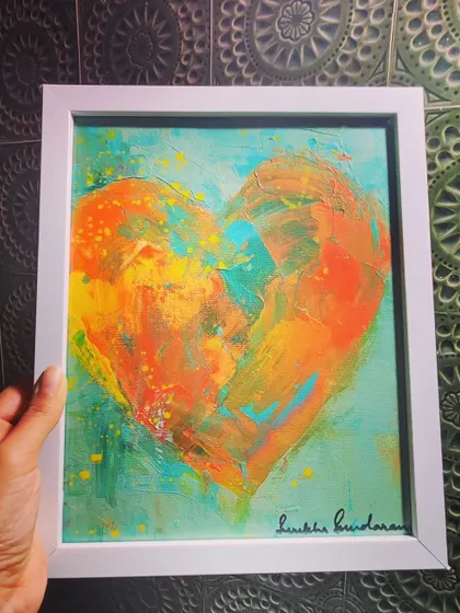 A duplicate shot of the "Eating the Frog" heart, held against a patterned tile background. The white frame makes the warm colors stand out beautifully.