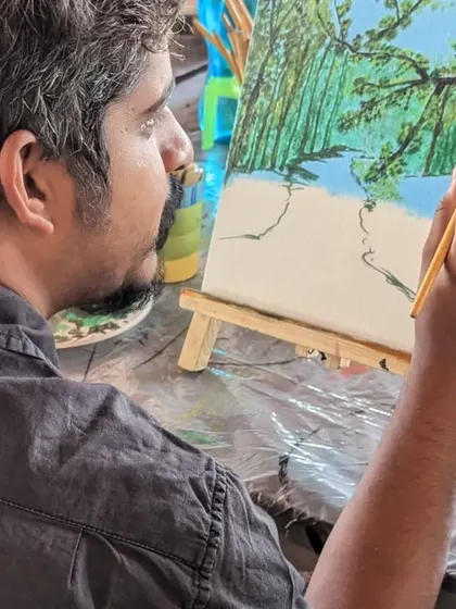 A participant working on a landscape painting, capturing the beauty of nature on his canvas.