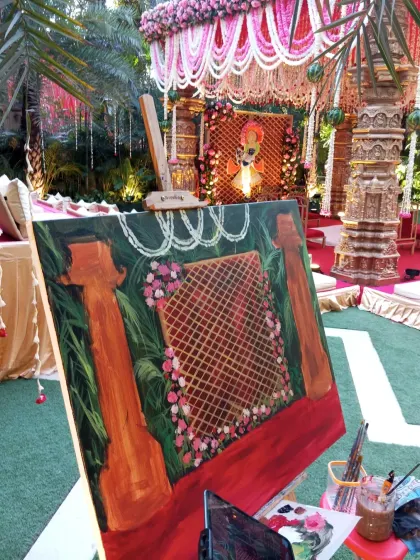 My easel set up against the stunning backdrop of Amaanta Farms in Delhi. Capturing the grandeur of the venue is the first step in creating a memorable live painting.