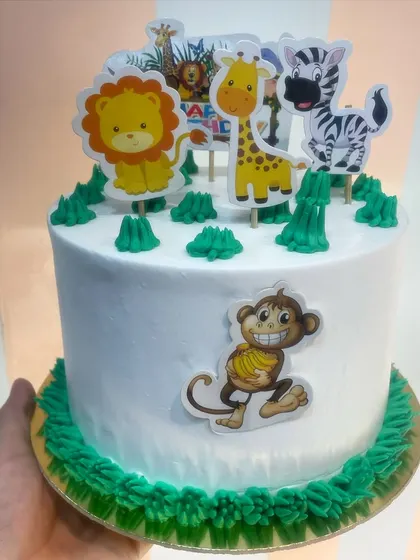 A simple and cute jungle theme cake, using edible toppers of a lion, giraffe, and zebra. This is a great option for a smaller, yet still festive, jungle party.