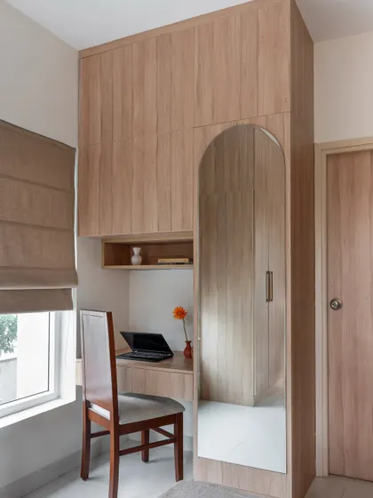 In another guest room, I designed this wardrobe with an integrated study desk and an arched dressing mirror, ensuring full functionality within a compact footprint.