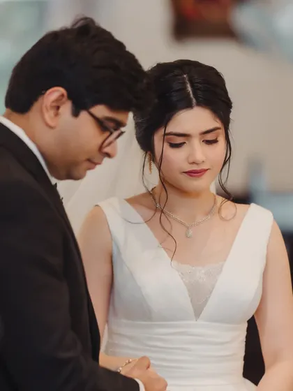 A quiet prayer during the ceremony. Her soft, elegant updo and natural makeup are the definition of timeless bridal beauty.