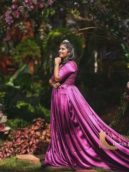 This magenta satin trail gown looks stunning in a lush, floral setting. The long tail can be arranged to create a beautiful path of color through the garden.