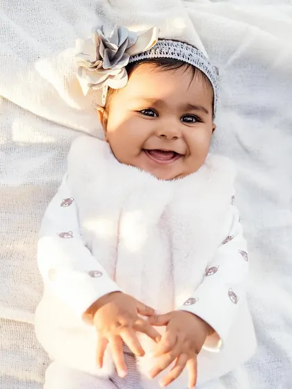 That heart-melting baby smile. This close-up shot captures the pure innocence and joy of a happy baby, all bundled up and cozy.