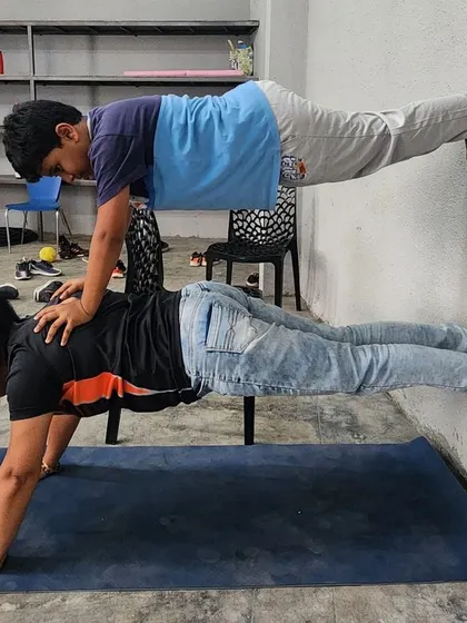 A duplicate of the previous image, showing a coach and camper in a wall-assisted double plank.