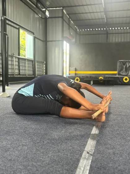 A student holds a seated forward bend, a great stretch for the hamstrings and lower back. We incorporate these stretches into every class.