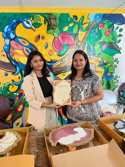 Another successful resin art creator, posing with her certificate and her unique, handcrafted piece.