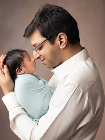 A father's love, so gentle and strong. He holds his tiny newborn, sharing a quiet moment of connection that beautifully illustrates the new bond being formed.