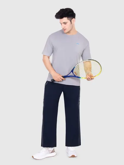 A full-body shot of a model wearing the sportswear outfit and holding a tennis racket, placing the apparel in an active, sporty context.