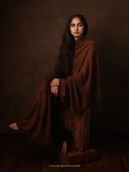 "I Dream my Painting & Paint my Dream." This portrait, with the subject seated on a rustic wooden block, has a raw, artistic, and grounded feel.