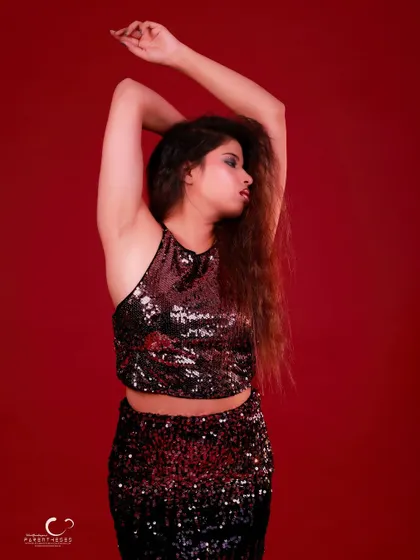 An elegant and artistic pose with arms raised. The composition is graceful and highlights the flow of her hair.