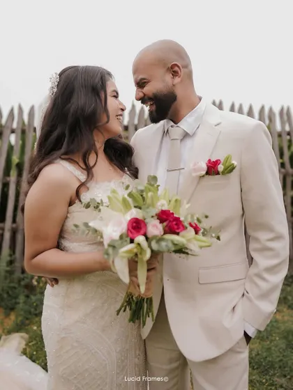 A happy, candid portrait of the couple, with the bride holding her beautiful bouquet.