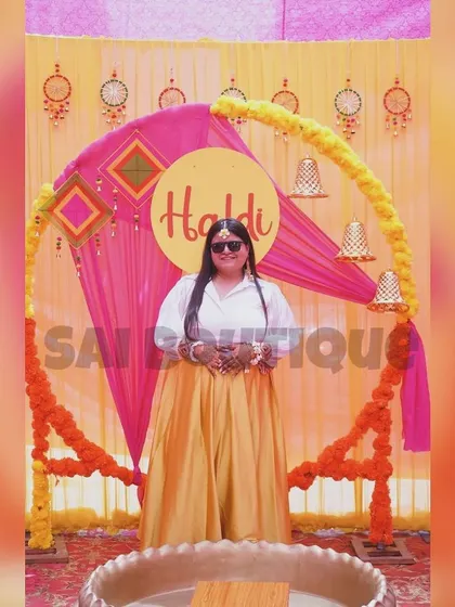 A happy client at her Haldi ceremony. She is wearing a simple yet elegant yellow skirt paired with a white shirt for a modern and comfortable look.