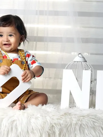 A simple and happy first birthday portrait. The bright smile and the "ONE" letters are all you need to capture the joy of this milestone.