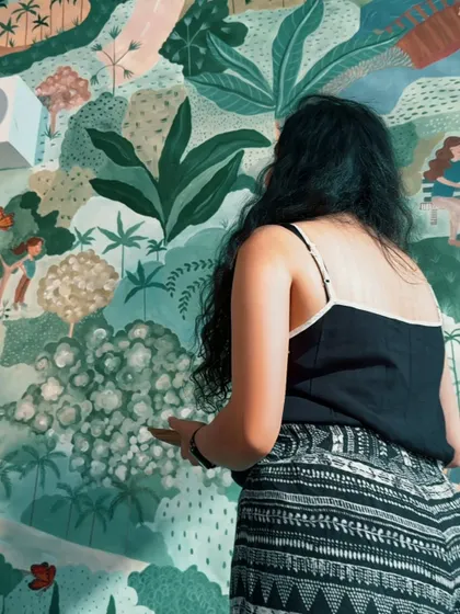 Every detail matters. Here, I'm adding fine touches to the foliage in the sustainable living mural, ensuring each element contributes to the overall narrative of community and nature.