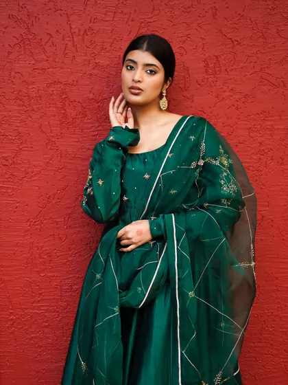 A close-up portrait that highlights the neckline and sleeve embroidery. This shot is essential for showing a designer's attention to detail in their festive collection.