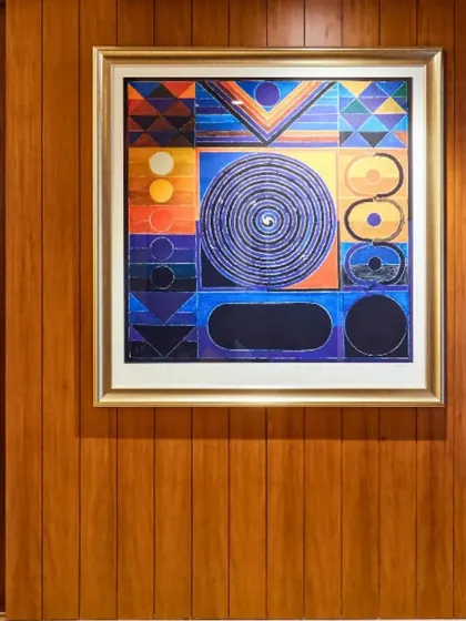 I often incorporate spiritual elements into my designs to foster positive energy. This geometric artwork, with its intricate patterns and vibrant colors, is set against a warm wood-paneled wall, creating a focal point that is both visually engaging and spiritually grounding.