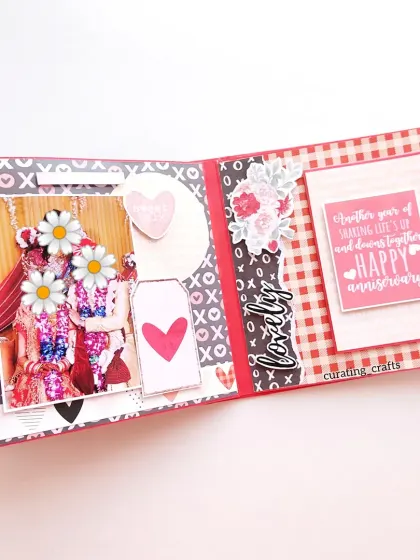An anniversary page with space for a sweet message and a photo, decorated with floral and heart embellishments.